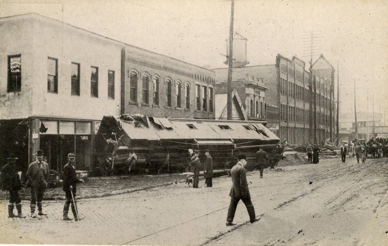 #112 Broad and Belle Streets during the 1913 flood, featuring an overturned streetcar, March 27, 1913.
