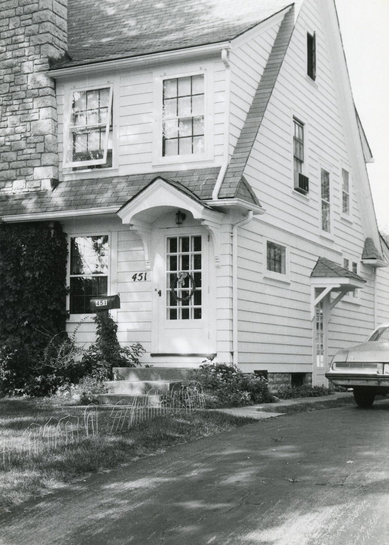 #128 Front door and right side of 451 S. Guernsey Ave. with a car in the driveway, Hilltop, 1980s.