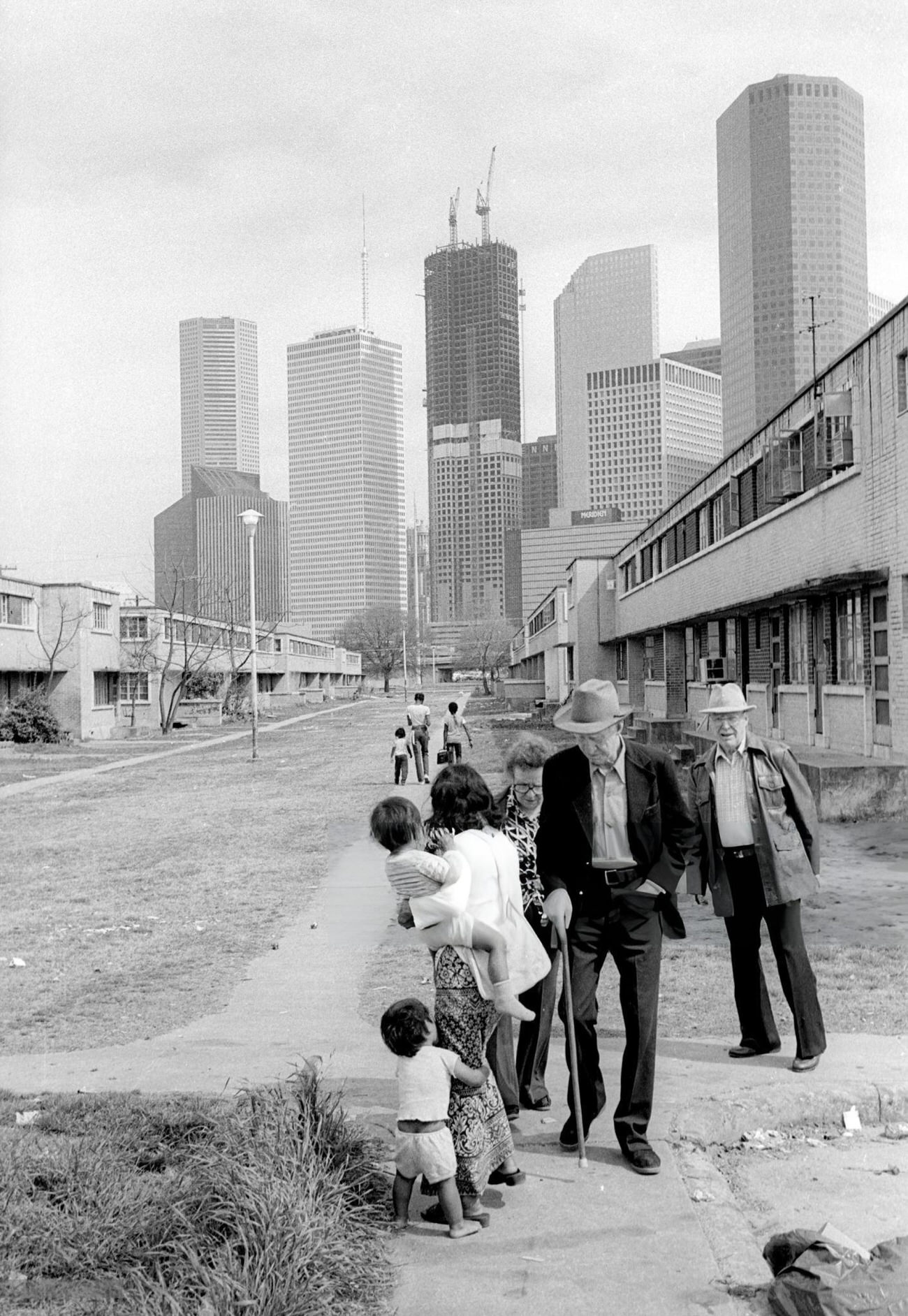 #50 Elderly white seniors pass an Asian mother and her children, Houston, Texas, 1983.