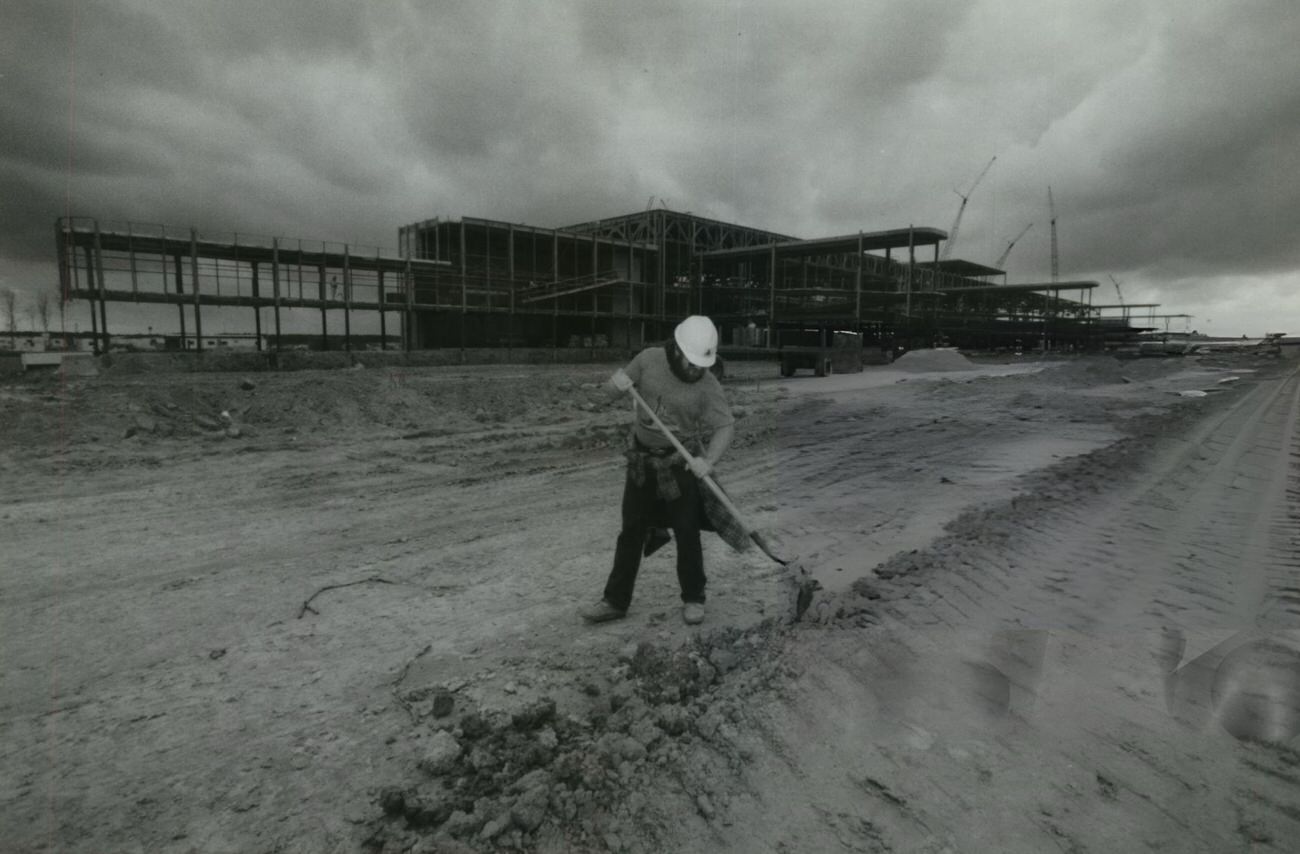 #78 A worker uses a shovel during construction of Terminal D at Intercontinental Airport, Houston, 1980s