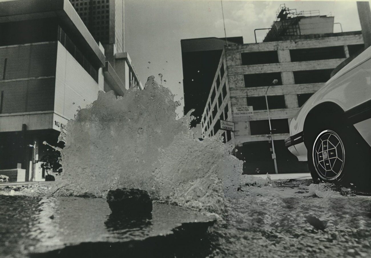 #45 A water main break creates an unplanned fountain at Milam and Prairie streets, Houston, Texas.