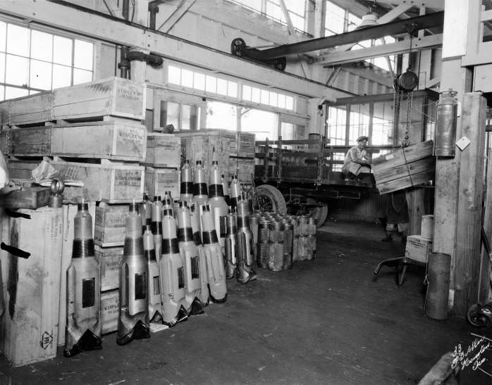 #30 Man guiding Hughes Tool Co. products onto a truck with a crane, 1940s