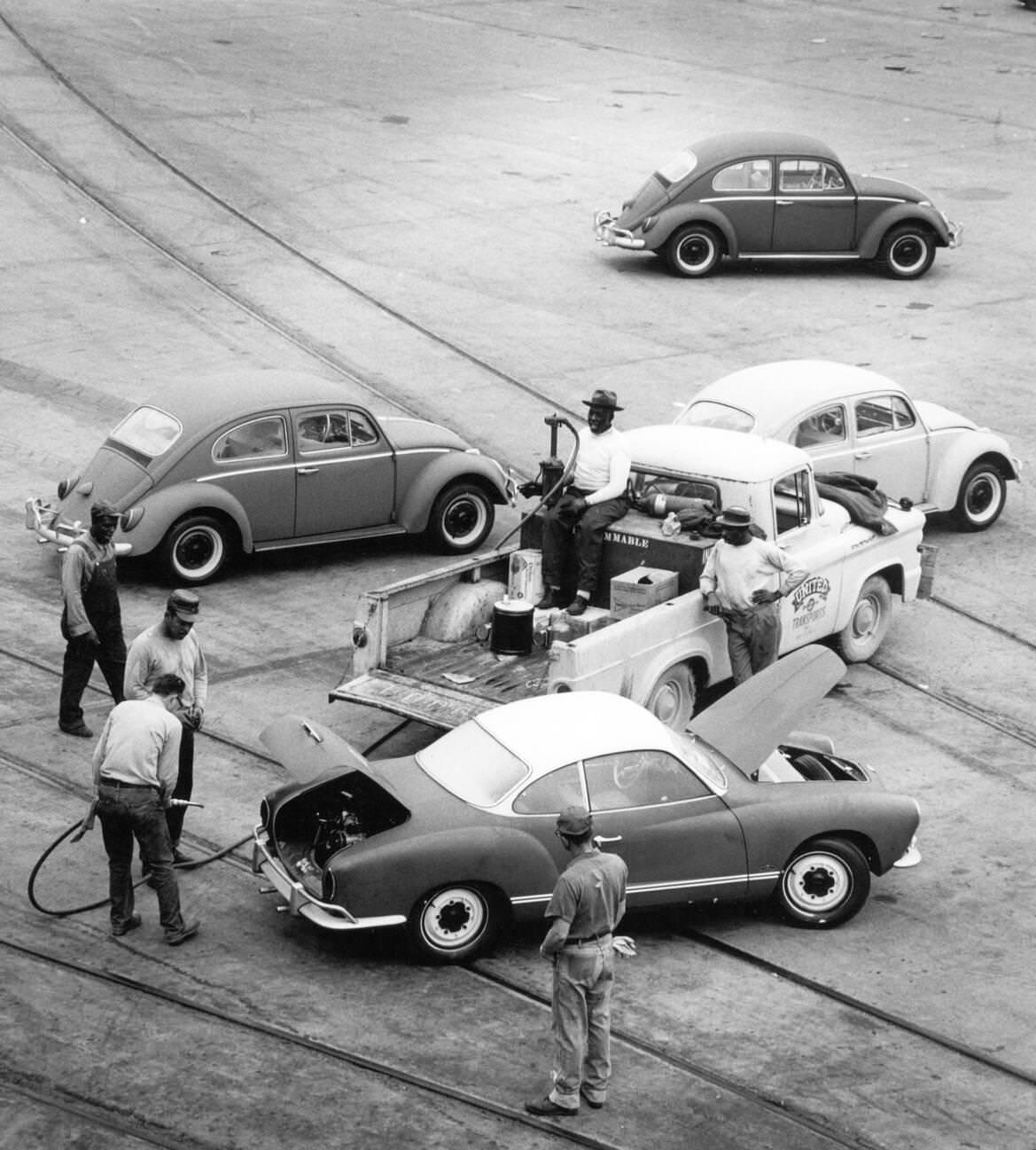#67 Volkswagen Beetles being refueled at the Houston harbor after importation, 1960s.