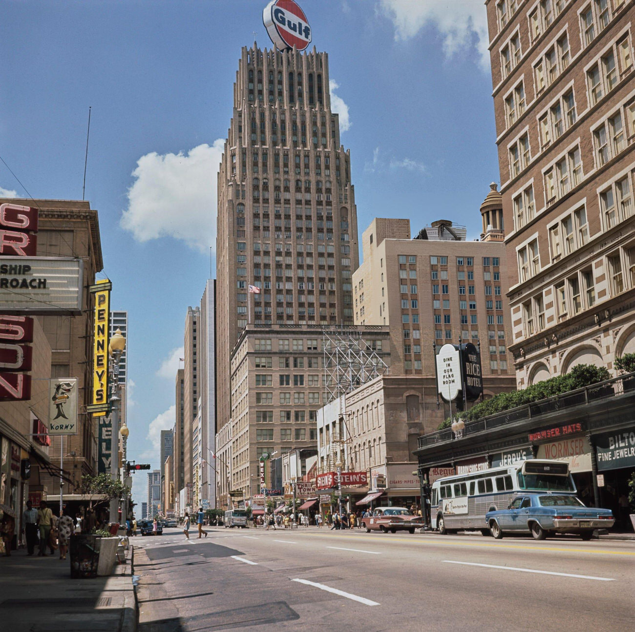 #31 Main Street scene with cars and a bus in downtown Houston, featuring the Gulf Building, circa 1970.
