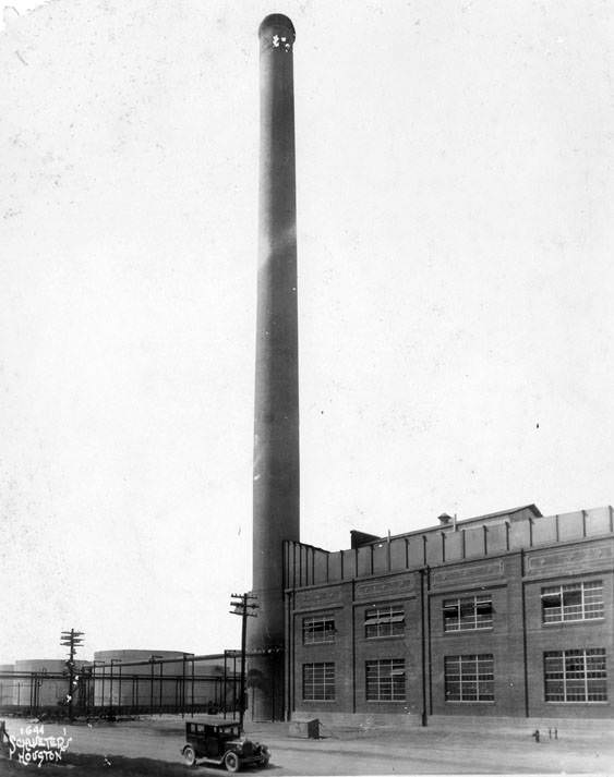 #78 Smokestack between building and petroleum storage tanks, 1920s.