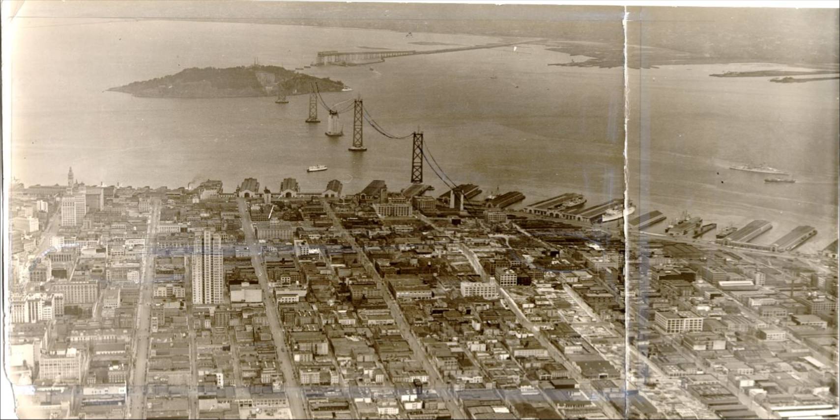 #106 Aerial view of the waterfront and the Bay Bridge under construction, 1935