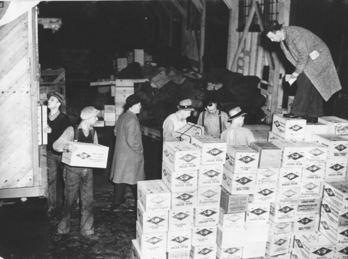 #122 Men unloading boxes from a truck, 1938