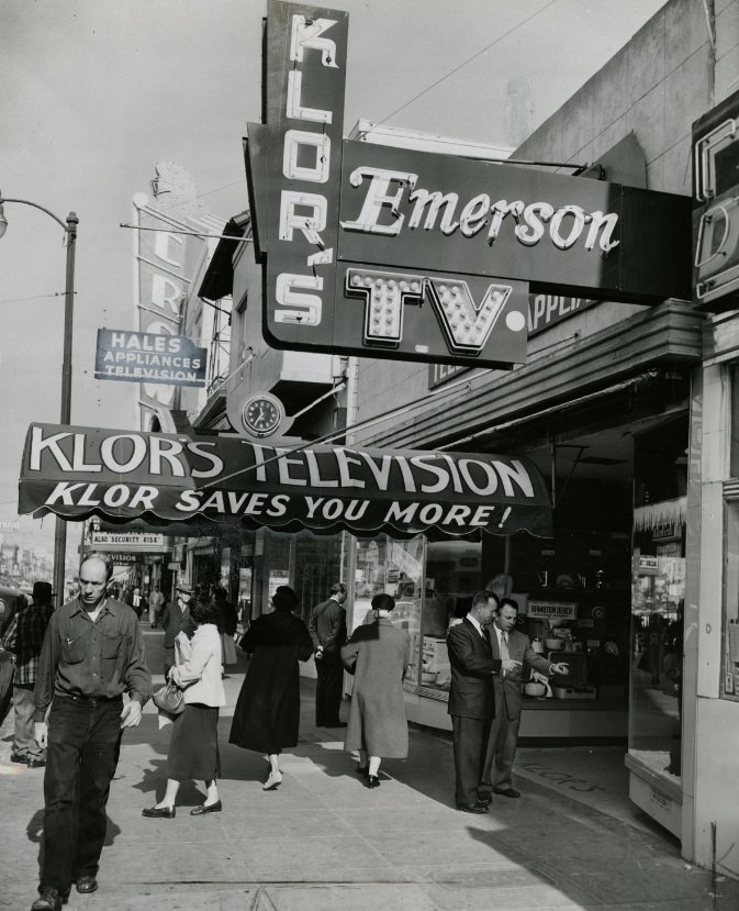 #54 George Klor and Al Schmidt outside Klor’s Television and Appliance store, 1954.