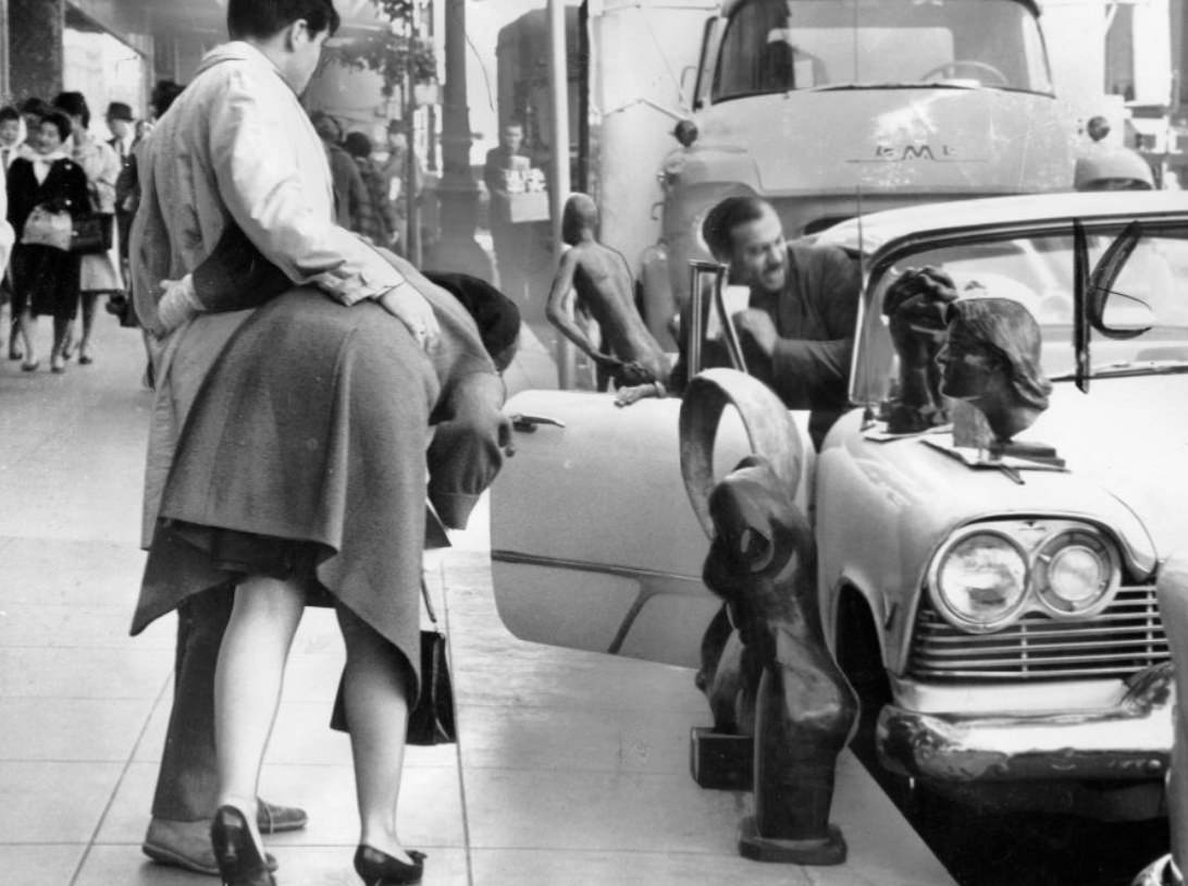 #33 Artist Elliott Moorez displaying sculptures on Geary Street, 1962.