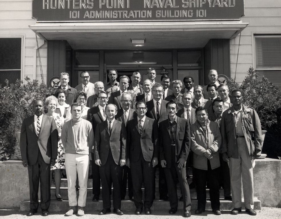 #161 Group posing in front of Hunters Point Naval Shipyard Administration Building, 1970.