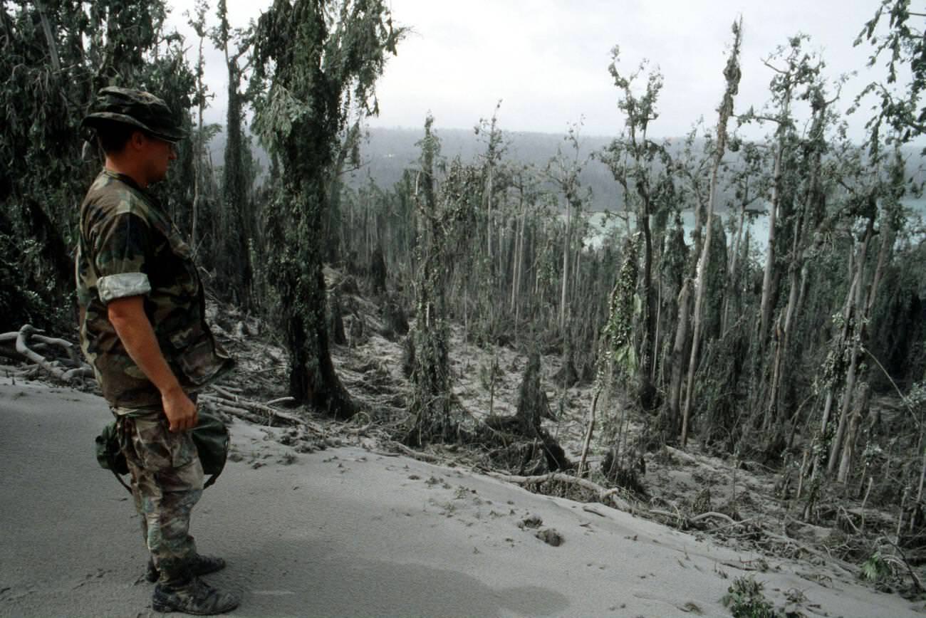 A sailor surveys damage at Naval Station Subic Bay, Luzon, Philippines, caused by volcanic ash from Mount Pinatubo’s eruption.