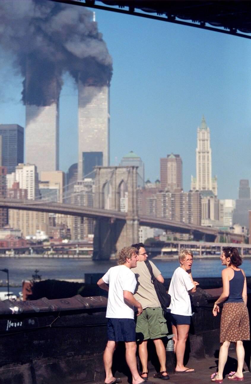 #16 Residents on the rooftop of an apartment building in Brooklyn watching the Twin Towers burn.