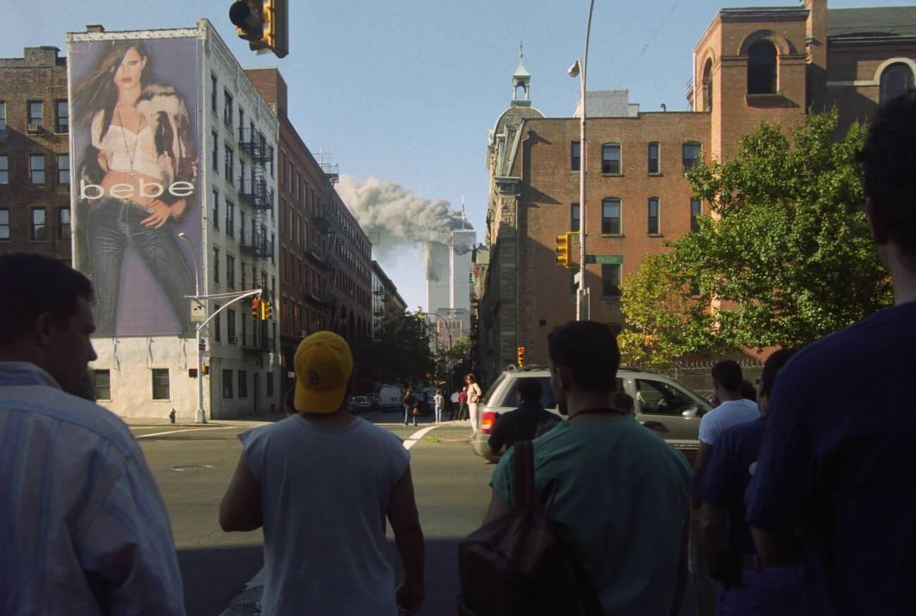 #21 New Yorkers watch the twin towers of the World Trade Center burn from Houston & Thompson Streets.