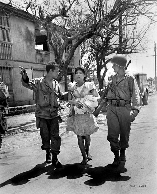 #3 American soldiers helping a Filipino lady to safety and help, Manila, Philippines, February 1945