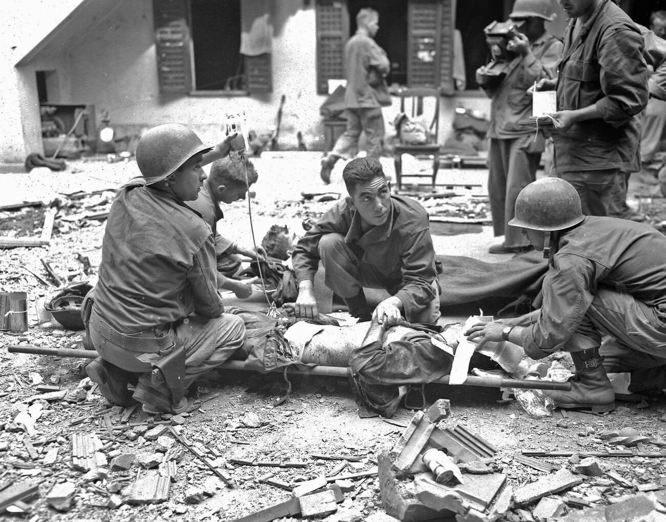 #72 Medics with the 37th Infantry Division administer plasma to a wounded soldier amid the Battle of Intramuros, 1945.