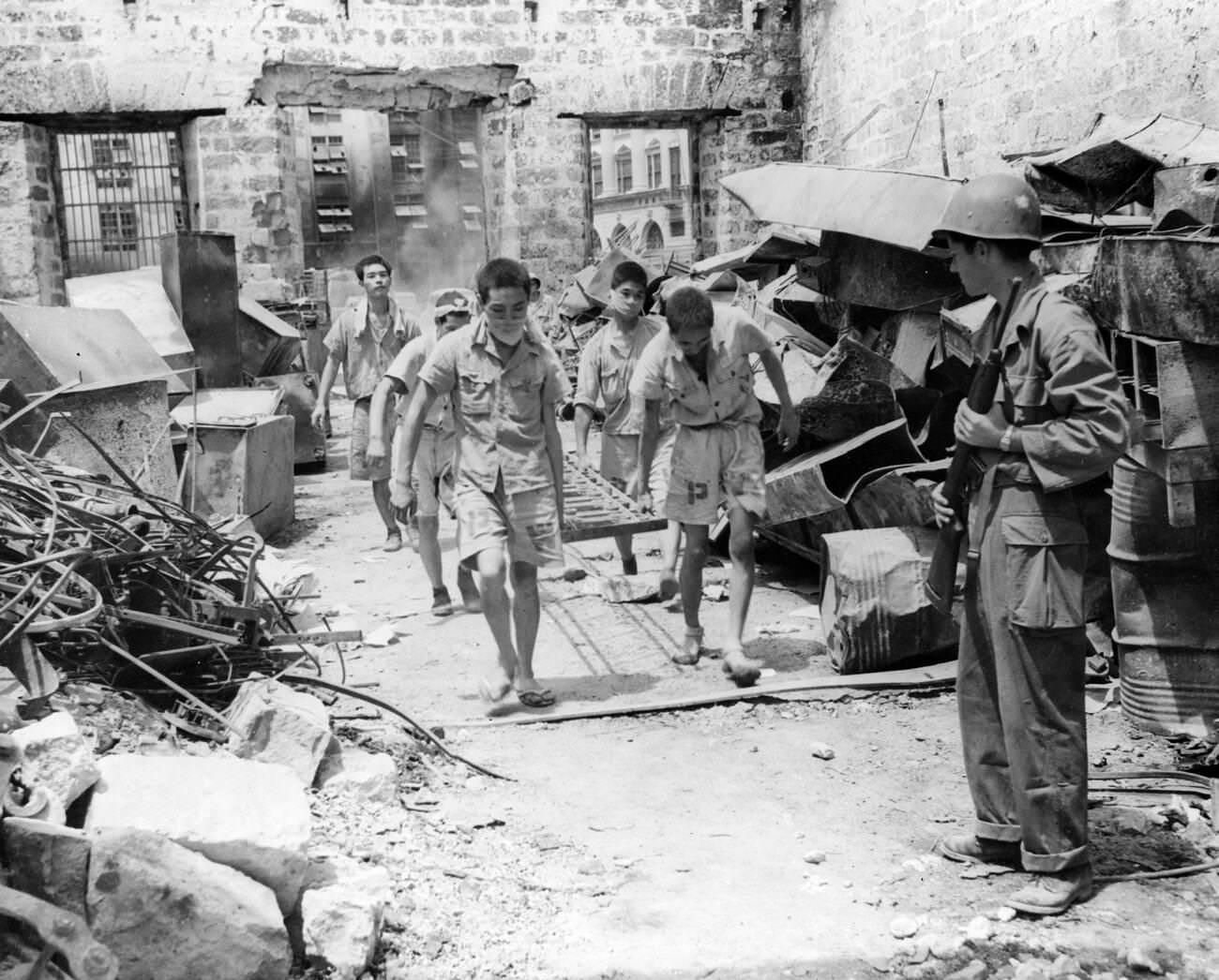 #40 Japanese prisoners of war are supervised by American military personnel, assisting in Manila’s cleanup after the battle, 1945.