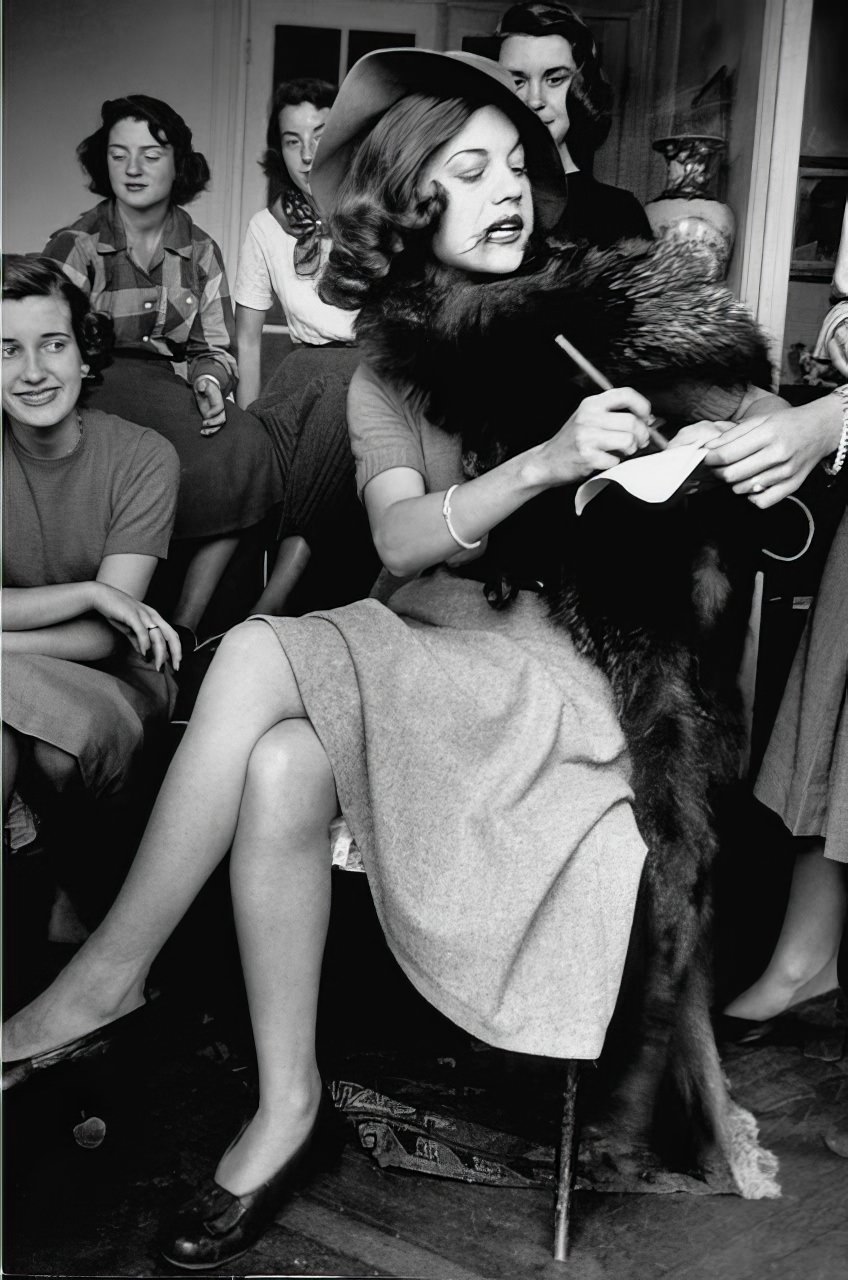 #16 Continental hauteur is burlesqued by Anne Montgomery, who pretends to sign autograph like Marlene Dietrich. Although the girls kid foreign ways, they share an affection for Paris. “In the States,” says one, “we were just some more Americans, but here we’re different and it’s a nice feeling.”