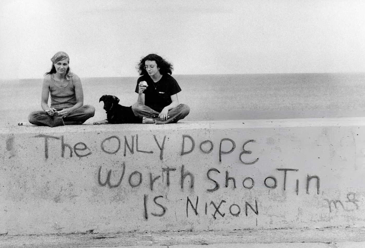 #12 Women sit on a wall with graffiti in Winthrop, Massachusetts, 1972.