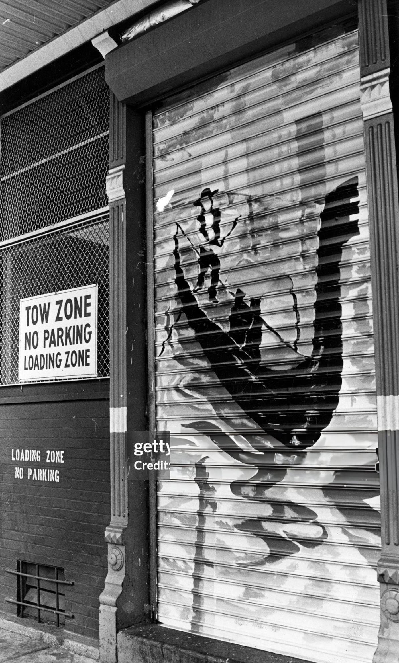 #18 Graffiti of a man on a gondola graces a loading zone door in Boston’s North End, 1978.