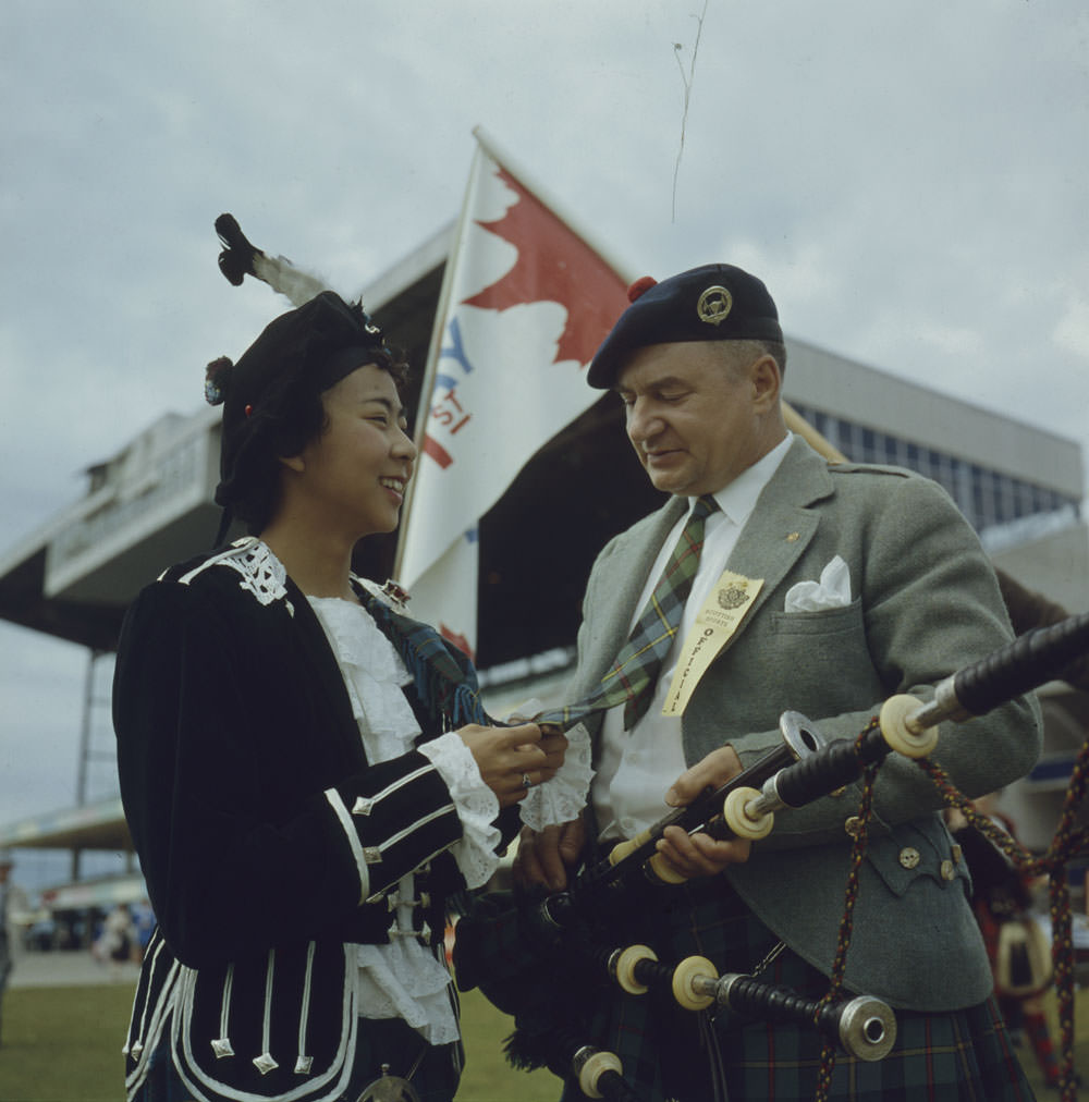 #30 Betty Chan admires Pipe Major Bill MacLeod’s tie, made from the MacLeod tartan, at a festival, Kildonan Park, Winnipeg, Manitoba