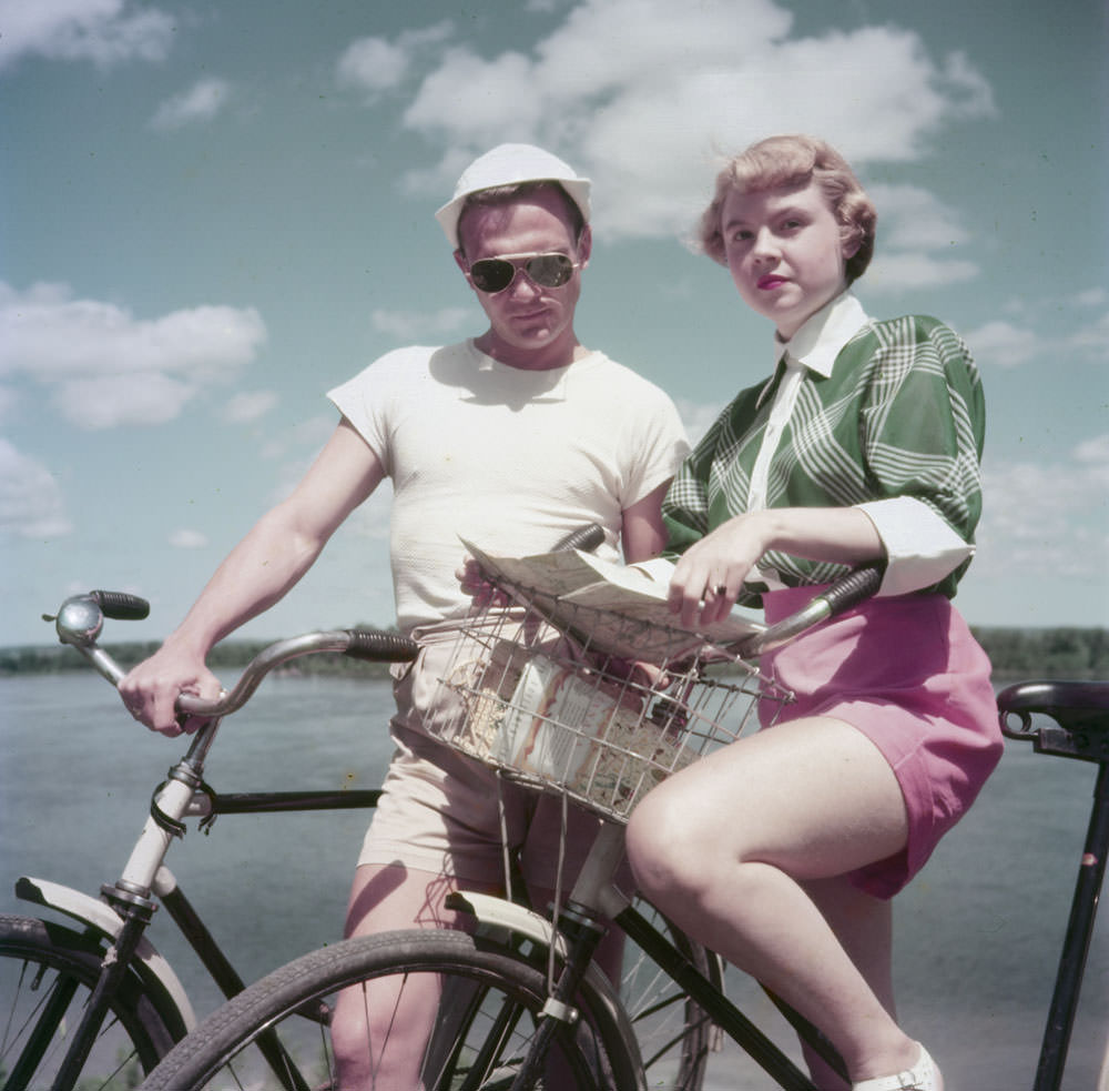 #1 A man and a woman on bicycles consult a road map on the bank of the Ottawa River, Rockcliffe Park, Ontario, June 1952