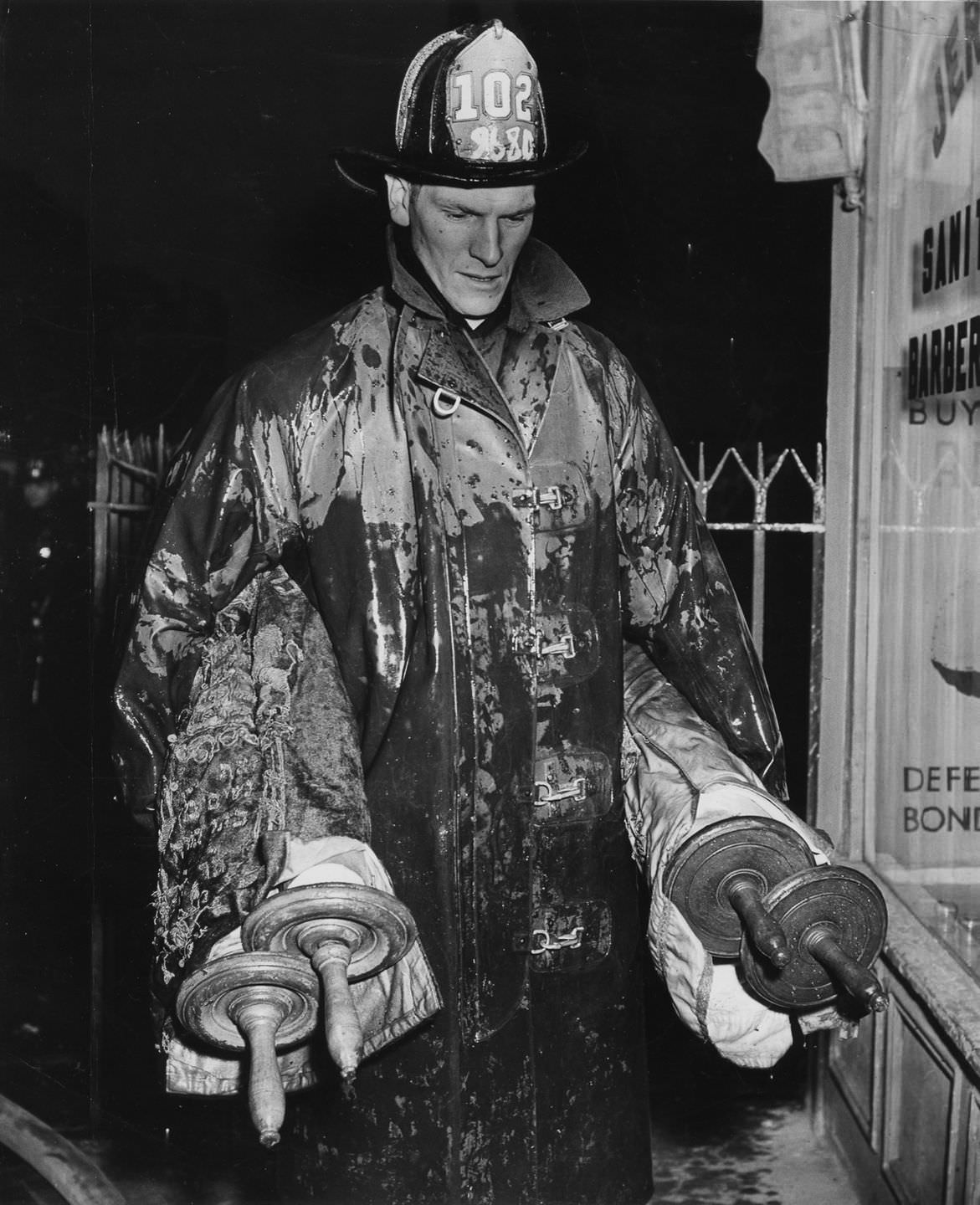 #8 A fireman holding Torahs saved from a fire, 1943.