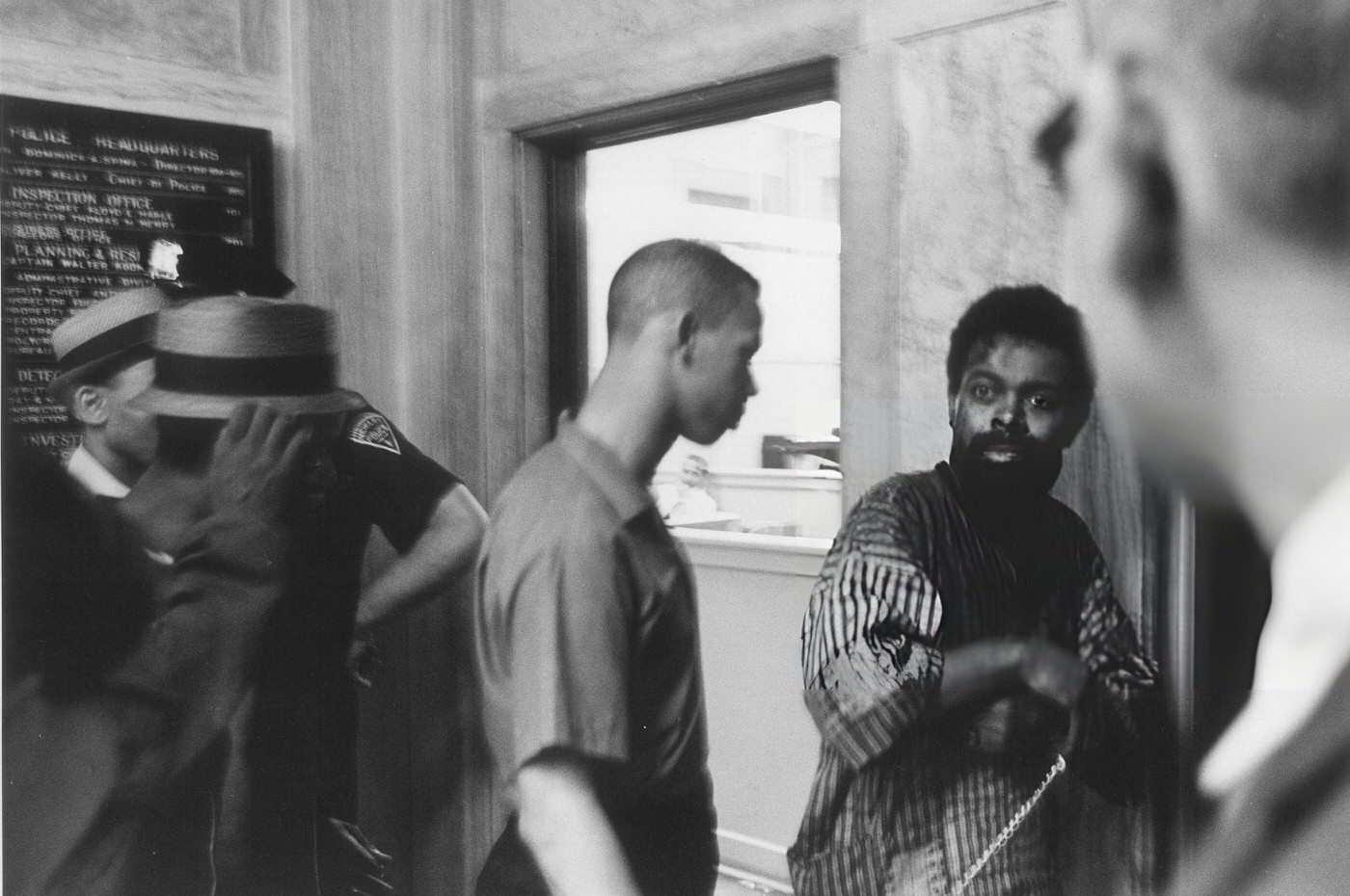 #30 LeRoi Jones in a police station, bloodied and in chains after being arrested.