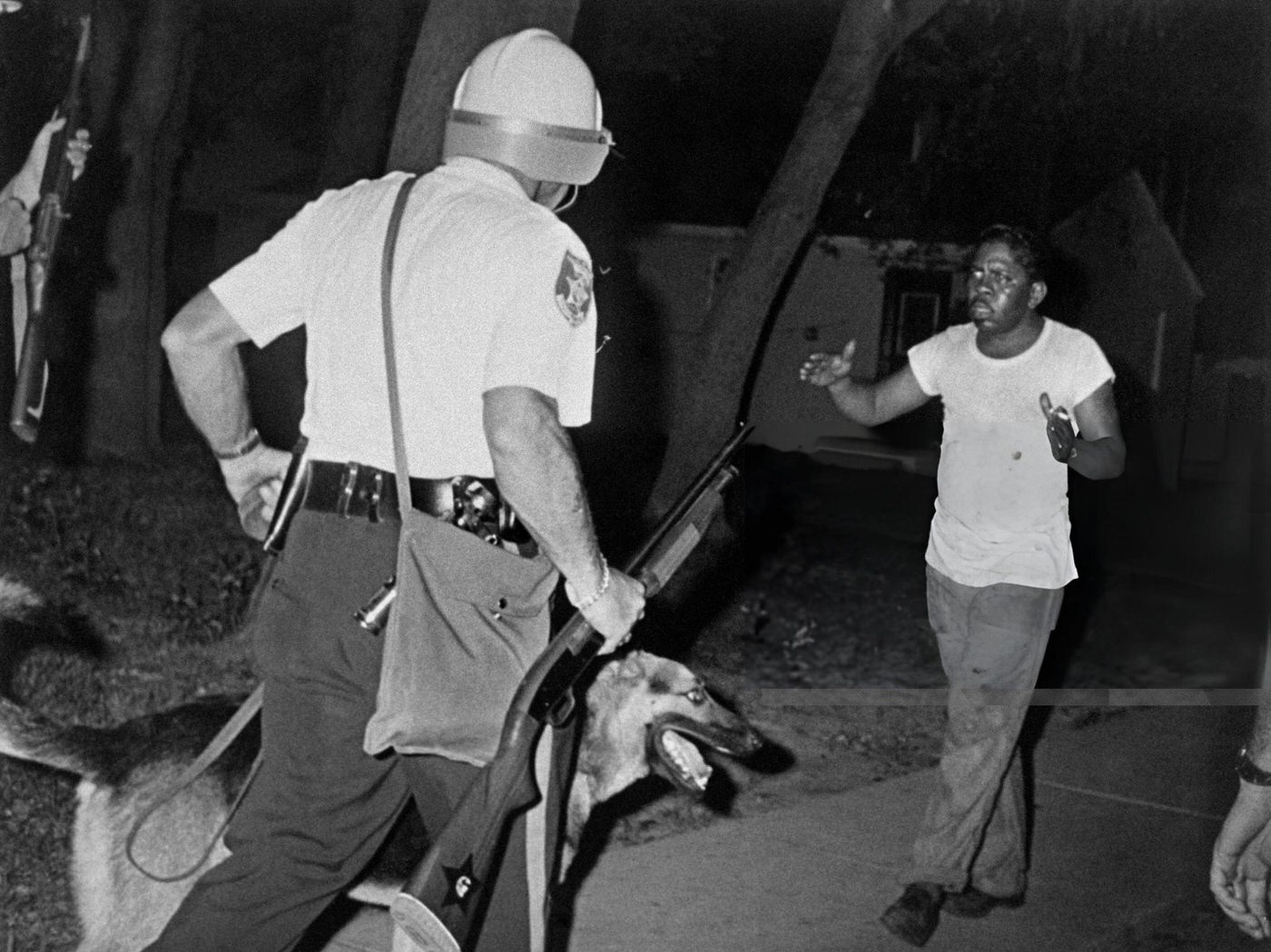 #31 Helmeted police riot argue with an African american man as Newark witnessed its second night of rioting, 1960s.