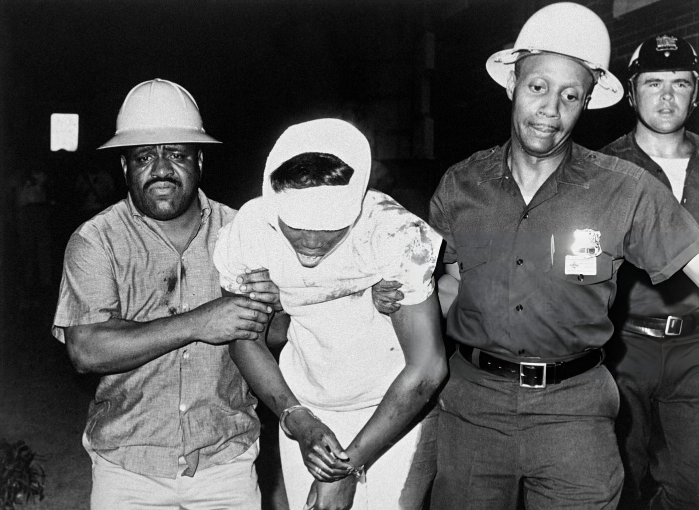 #36 Helmeted police riot guards drag a wounded rioter away from the scene of violence