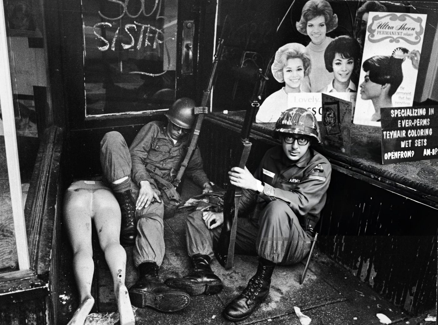 #10 National Guardsmen rest in front of a hairdressers shop
