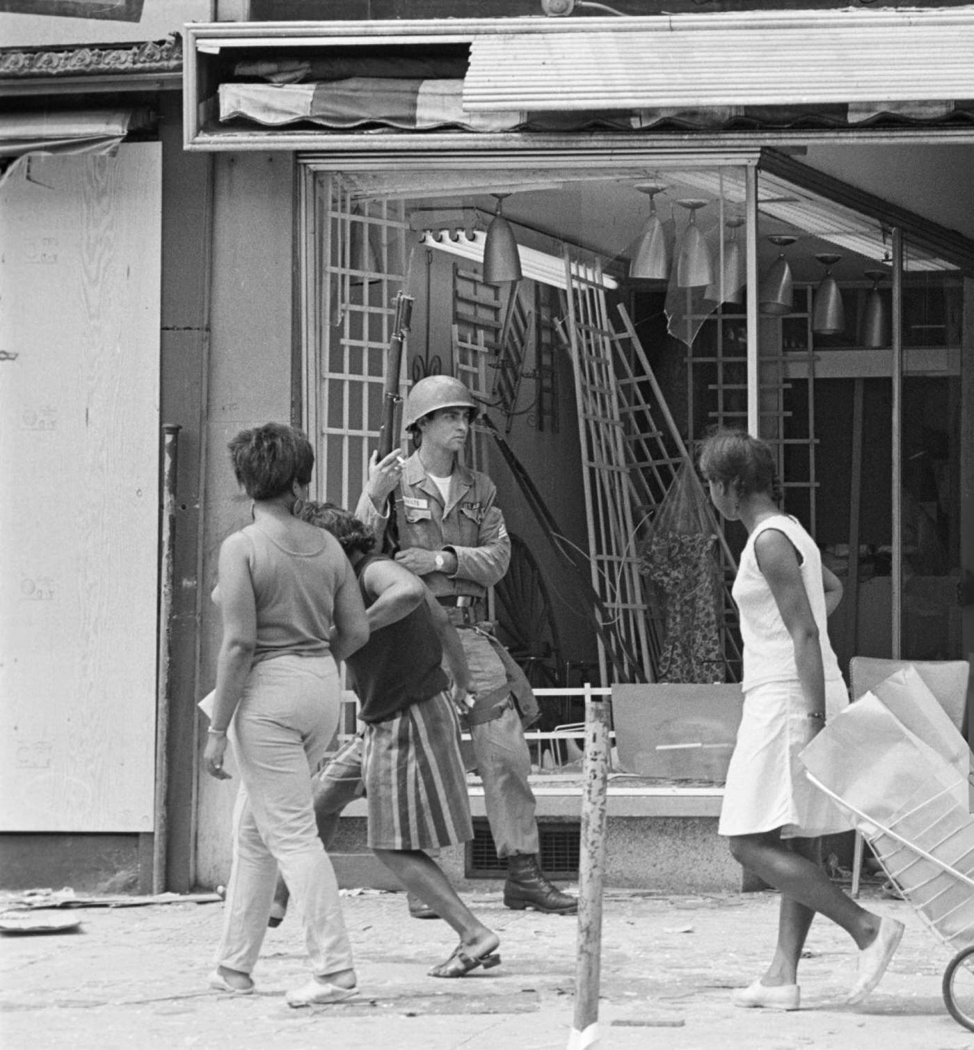 #62 A National Guard soldier stands guard in front of a looted and gutted store