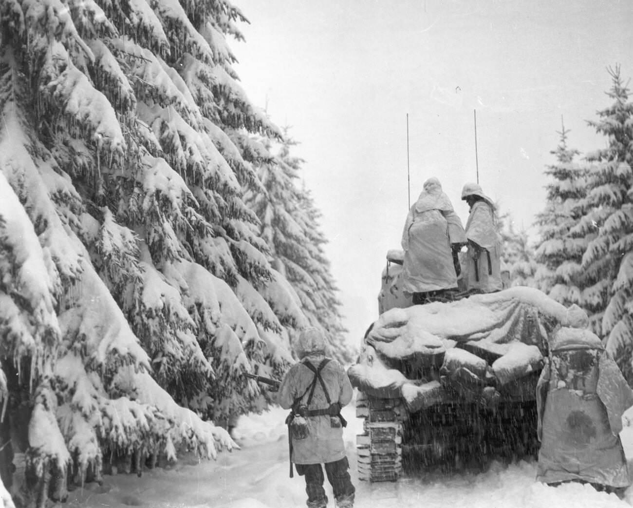 #17 Tanks and infantrymen of the 82nd Airborne Division push through the snow in Belgium, 1944.