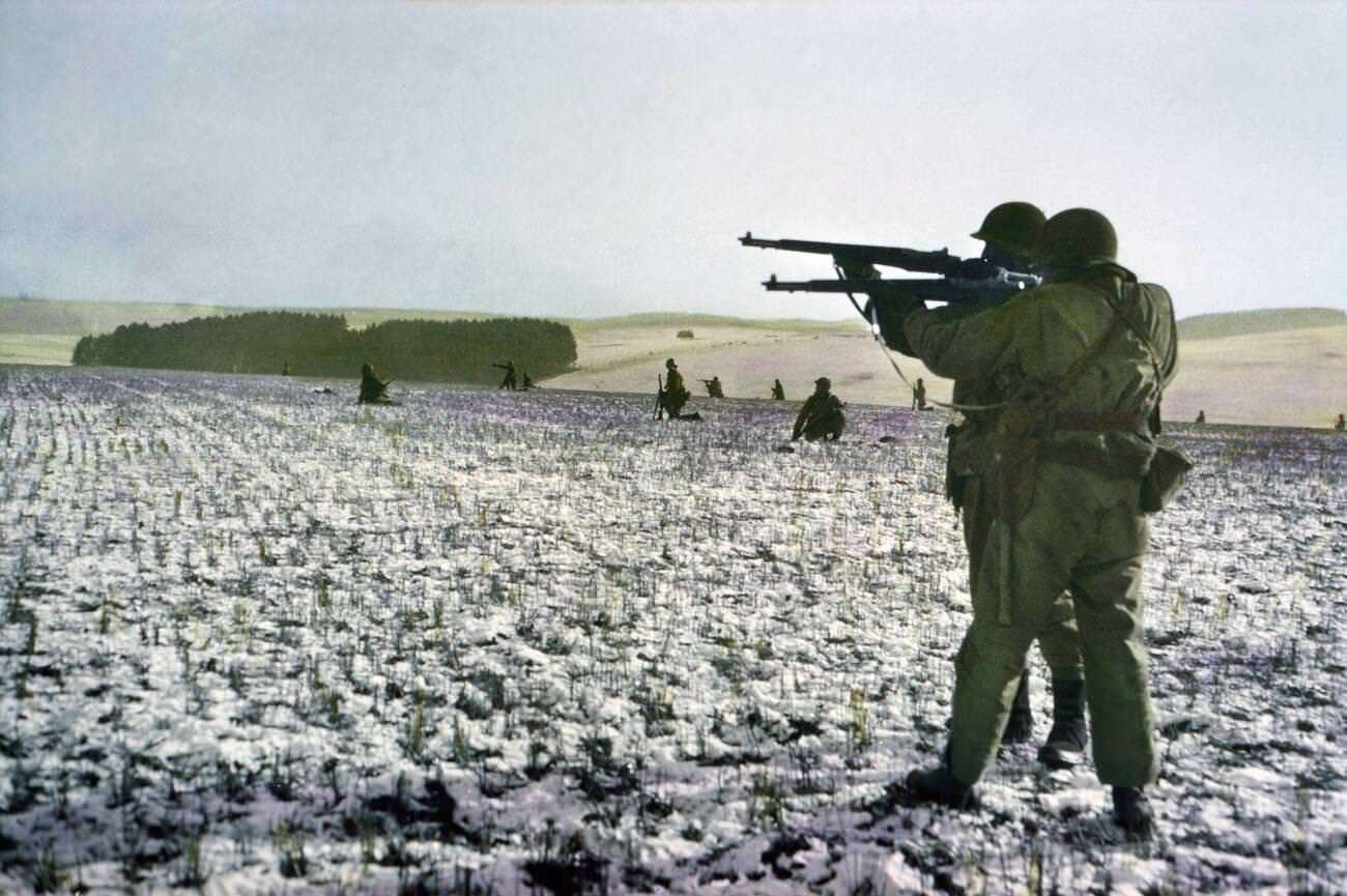 #31 Infantrymen fire at German troops in advance to relieve surrounded paratroopers, Bastogne, Belgium, 1944.