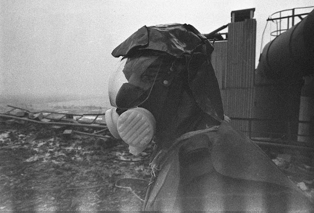 #8 A liquidator, outfitted with handmade lead shielding on his head, works to clean the roof of reactor No. 3.