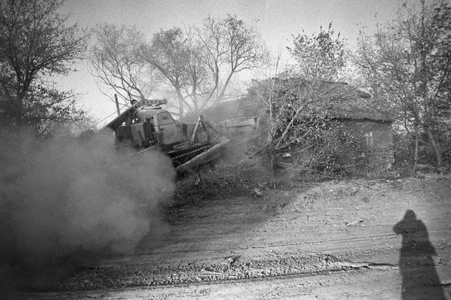 #9 A bulldozer digs a large trench in front of a house before burying the building and covering it with earth.