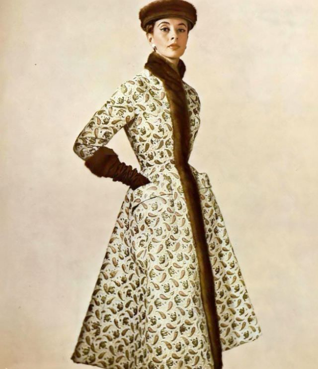 #11 Marie-Thérèse in a gold brocade coat of Persian design, a high stand-up collar of mink that extends down the front, by Pierre Balmain, 1954.