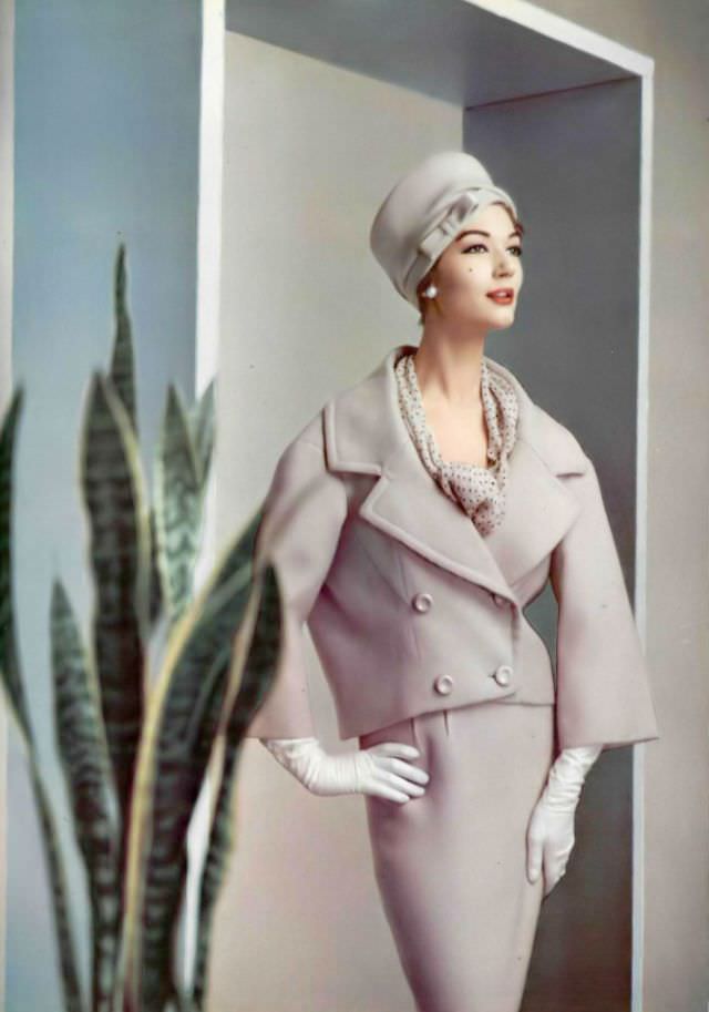 #24 Simone d’Aillencourt in a lilac wool suit, the collar and lapels are widened and the jacket tilts slightly to the back, by Pierre Balmain, 1957.