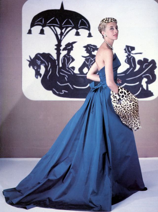#3 Balmain mannequin Marie-Thérèse models his evening gown accented with a leopard hat and muff, 1953.