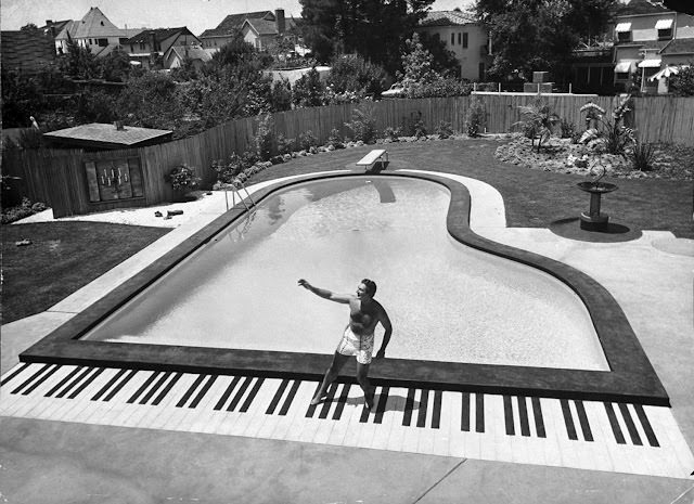 #8 Liberace playing the piano at his California home, 1954.