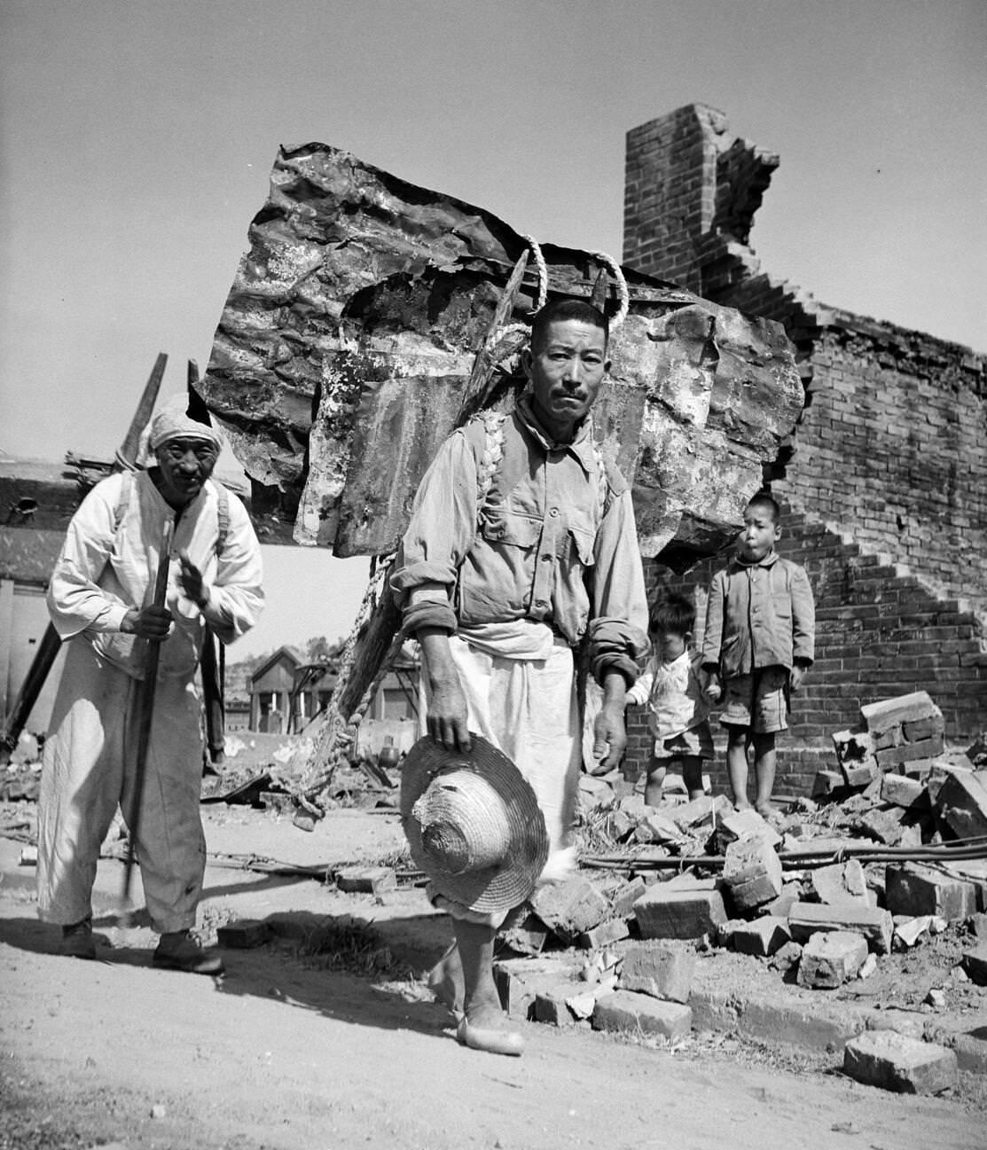 #12 Civilians recovering building materials from the ruins in Inchon during the Korean War, 1950s.