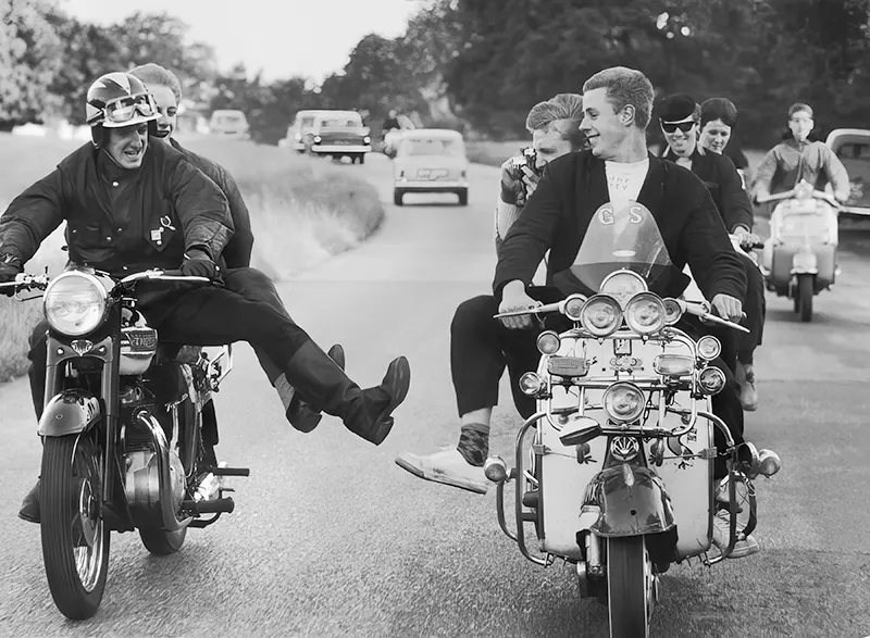 #3 A rocker tries to kick over a rival mod’s scooter in England, 1964.