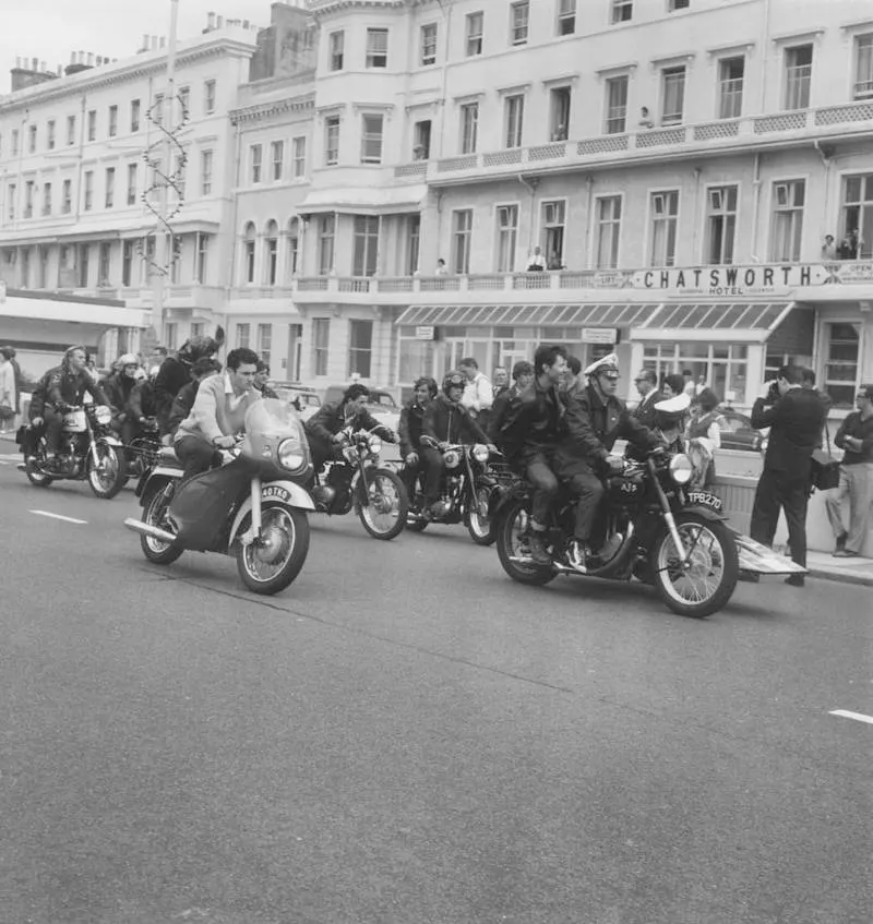 #6 A lone mod drives his scooter up alongside a group of rockers in Hastings, England, 1964.