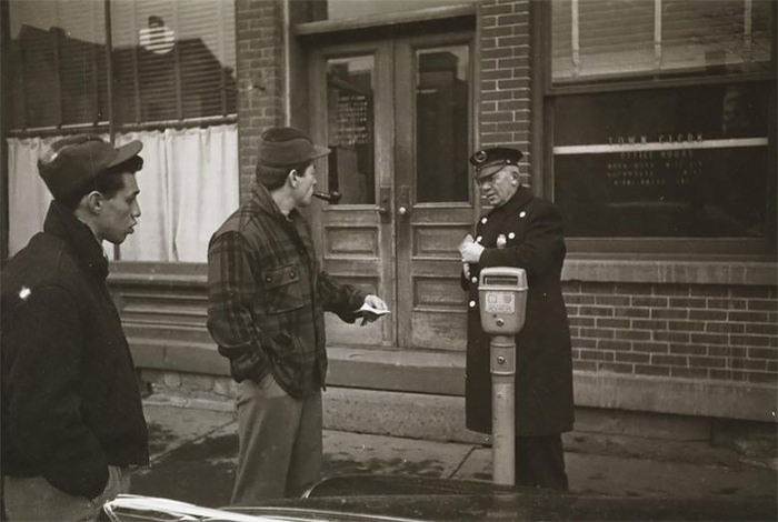#62 Rocky Graziano talking to a policeman on a street.