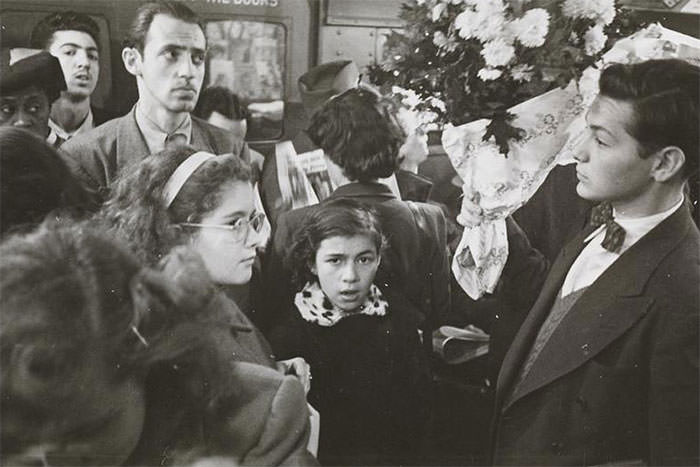 #70 A man carrying flowers on a crowded subway, 1946.