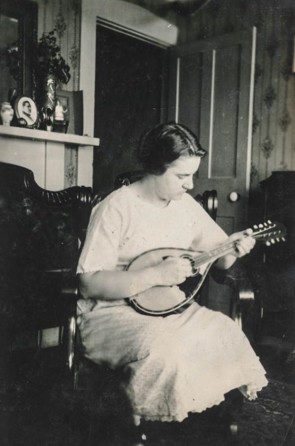 #25 Woman plays a mandolin in her bedroom