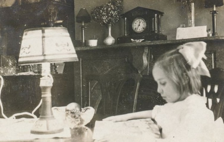 #8 Little girl reading at a table
