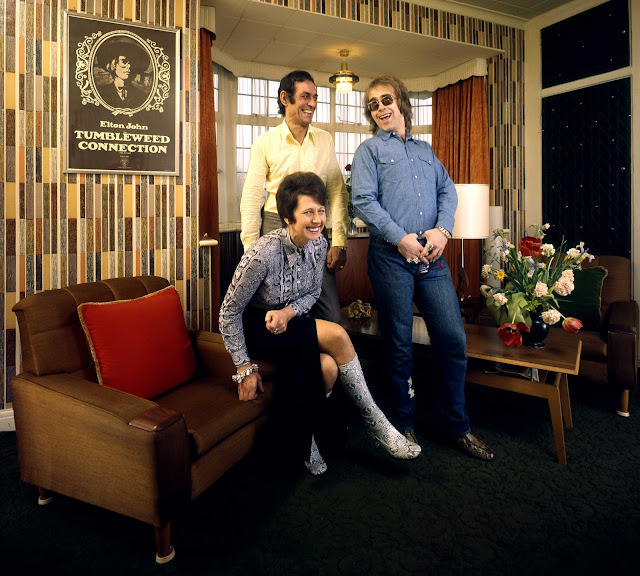 The former Reggie Dwight, later known as Elton John, laughs with his mom Sheila Fairebrother and her husband Fred (whom he affectionately called “Derf,” Fred spelled backwards) in their suburban London apartment in 1970.
