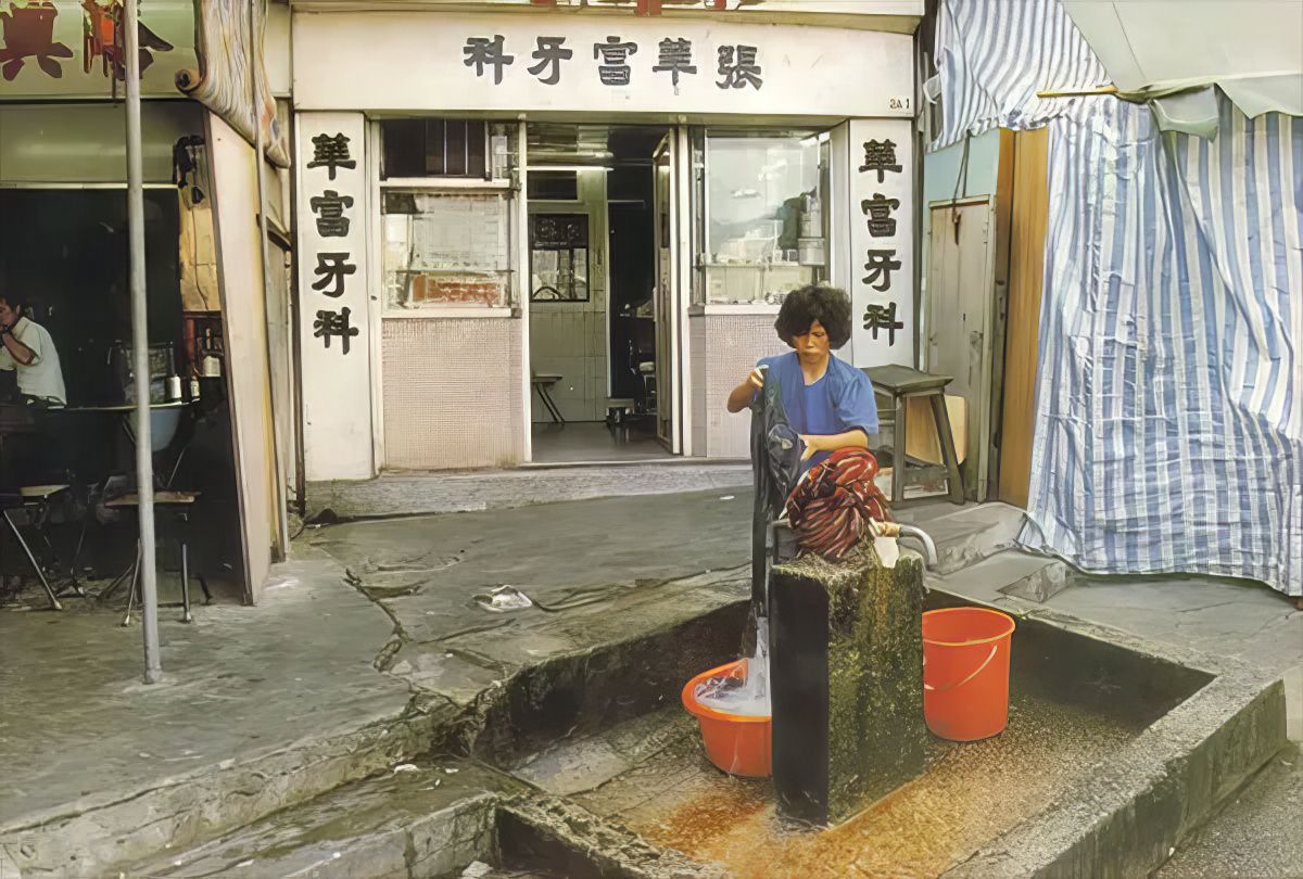 #11 A woman fetches water in Kowloon Walled City.
