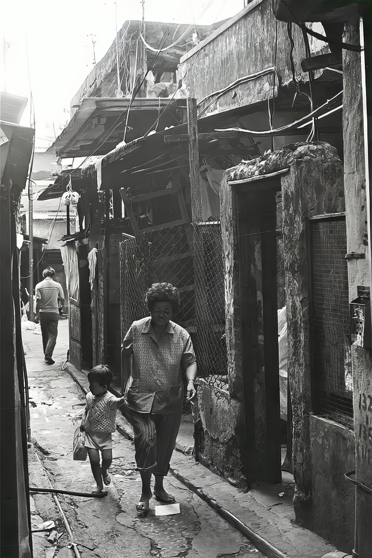 #14 A woman and a girl make their way through Kowloon Walled City.
