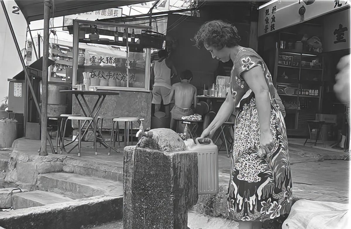 #9 A woman gathering water in Kowloon Walled City.